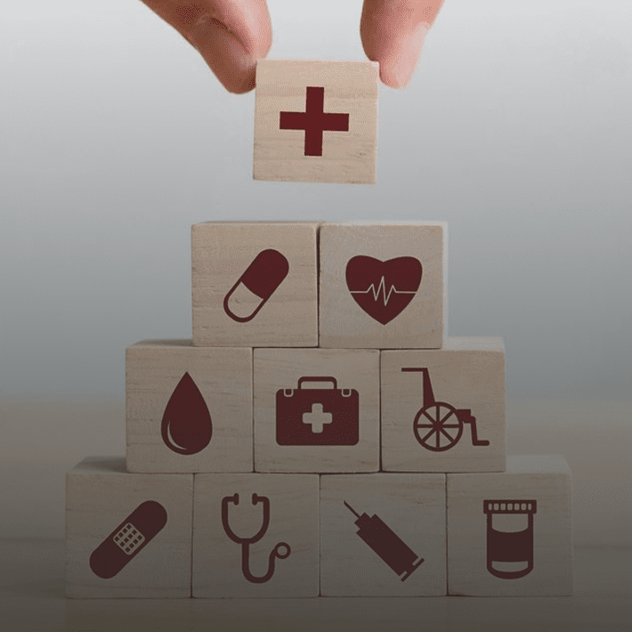Healthcare symbols on stacked wooden blocks.